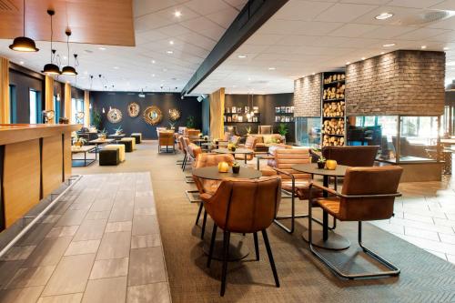 a lobby of a restaurant with tables and chairs at Radisson Blu Hotel Nydalen, Oslo in Oslo