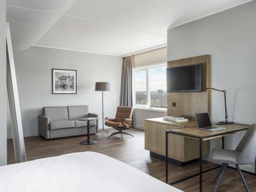 a hotel room with a bed and a desk with a laptop at Radisson Blu Hotel Nydalen, Oslo in Oslo