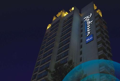 a tall building with a hotel sign at night at Radisson Blu Ankara in Ankara