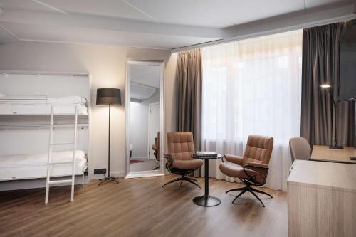 a bedroom with a bunk bed and two chairs at Radisson Blu Hotel Nydalen, Oslo in Oslo