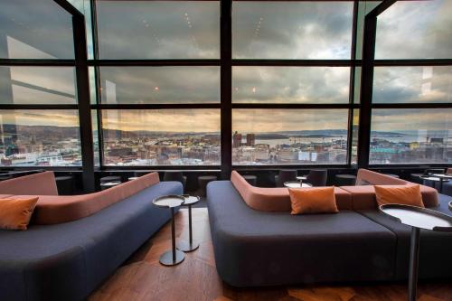 a room with two couches in front of a large window at Radisson Blu Scandinavia Hotel, Oslo in Oslo