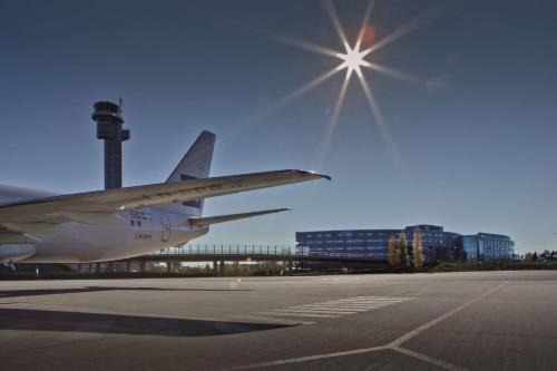 um avião está estacionado num aeroporto com o sol no céu em Radisson Blu Airport Hotel, Oslo Gardermoen em Gardermoen