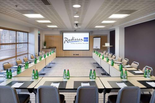 a conference room with tables and chairs and a screen at Radisson Blu Hotel Olümpia in Tallinn