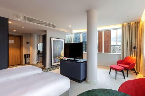 a bedroom with a bed and a flat screen tv at Radisson Blu Hotel Lietuva in Vilnius