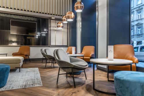 布拉格Radisson Blu Hotel Prague的一间设有桌椅的等候室