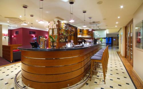 a bar in a restaurant with a wooden bar counter at Radisson Blu Ridzene Hotel, Riga in Rīga