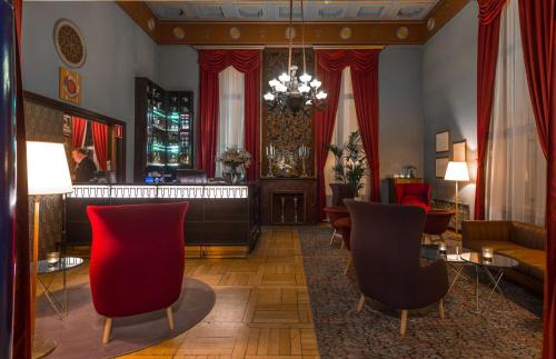 a living room with a bar with red chairs at Radisson Blu Grand Hotel Tammer in Tampere