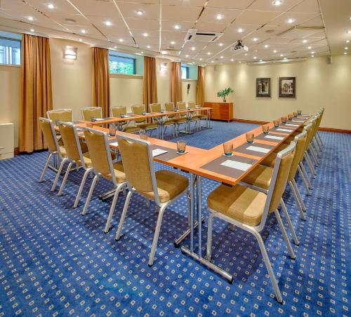 a conference room with a long table and chairs at Radisson Blu Ridzene Hotel, Riga in Rīga