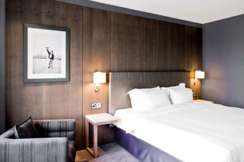 a hotel room with a bed and a chair at Radisson Blu Manchester Airport in Hale