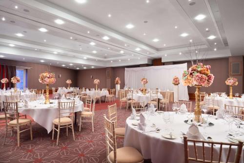 a banquet hall with white tables and chairs at Radisson Blu Hotel, Durham in Durham