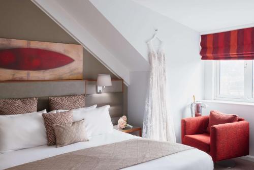 a bedroom with a bed and a red chair at Radisson Blu Hotel, Durham in Durham
