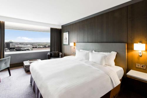a hotel room with a large bed and a large window at Radisson Blu Manchester Airport in Hale