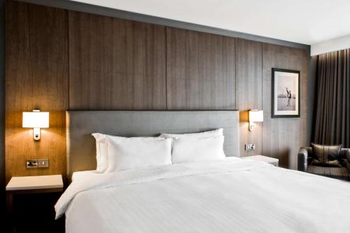 a bedroom with a large white bed and a chair at Radisson Blu Manchester Airport in Hale