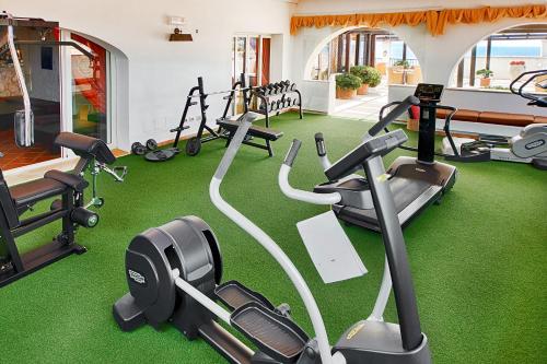 a gym with several treadmills and exercise bikes at Colonna Grand Hotel Capo Testa in Santa Teresa Gallura