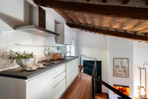 a kitchen with white cabinets and a stove at Porta Castellana B&B - Apartment in Montalcino