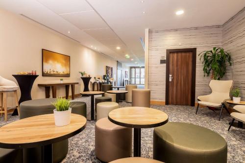a waiting room with tables and chairs at Radisson Blu Hotel Paris, Marne-la-Vallée in Magny-le-Hongre