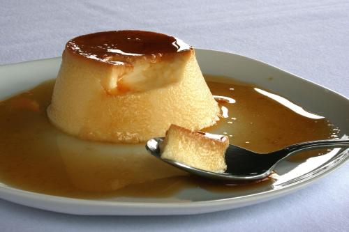 a piece of cake on a plate with a spoon at Posada Ruilobuca in Ruiloba