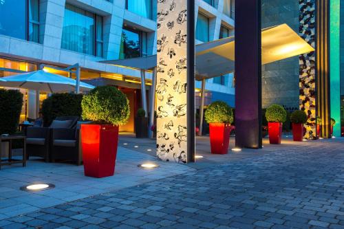 eine Reihe roter Pflanzen vor einem Gebäude in der Unterkunft Radisson Blu Media Harbour Hotel, Düsseldorf in Düsseldorf