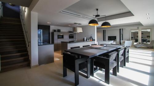 a kitchen and dining room with a black table and chairs at Domaine De Manville in Les Baux-de-Provence