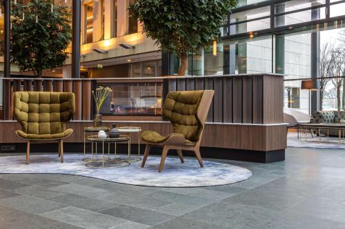 duas cadeiras e uma mesa em frente a um edifício em Radisson Blu Hotel Köln em Colónia