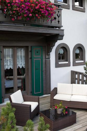 a patio with two chairs and a green door and flowers at Bellevue in Les Gets
