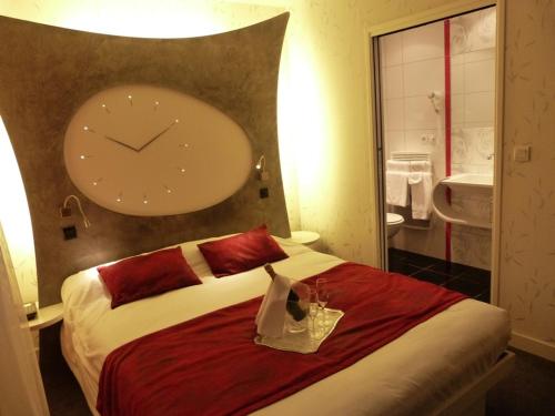 a room with a bed with a clock on the wall at Domaine du Revermont - Logis Hotel in Passenans