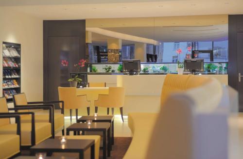 a restaurant with yellow chairs and tables and a counter at Radisson Blu Hotel, St. Gallen in St. Gallen