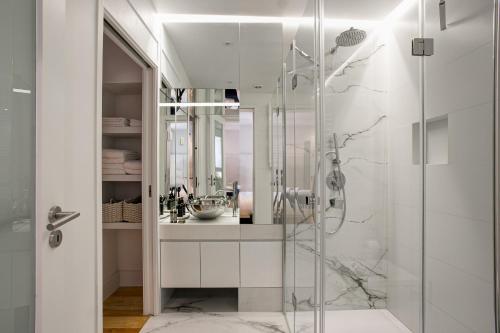 La salle de bains est pourvue d'une douche en verre et d'un lavabo. dans l'établissement Chic & Trendy T.M. Flat, à Lisbonne