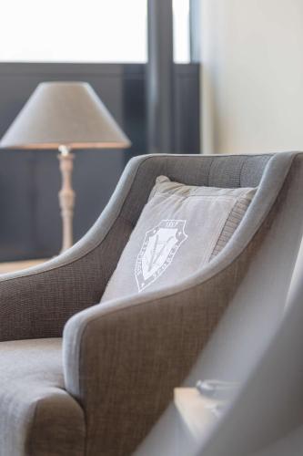 a couch with a pillow on it next to a lamp at Radisson Blu Hotel, St. Gallen in St. Gallen