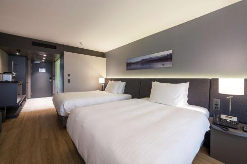 a hotel room with two beds and a television at Radisson Blu Hotel, Lucerne in Luzern
