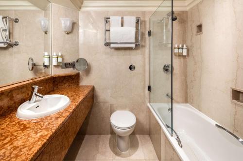 a bathroom with a sink and a toilet and a shower at Radisson Blu Edwardian Heathrow Hotel, London in Hillingdon