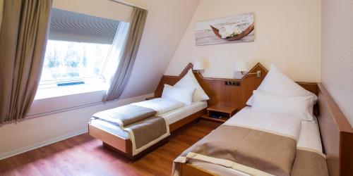 Un pat sau paturi într-o cameră la Hotel Hangelar