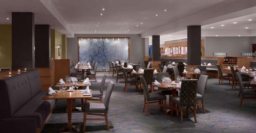 um restaurante com mesas e cadeiras num quarto em Radisson BLU Hotel and Spa, Limerick em Limerick