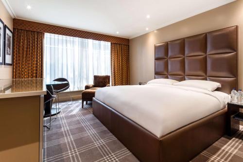 a hotel room with a large bed and a desk at Radisson Blu Edwardian Heathrow Hotel, London in Hillingdon