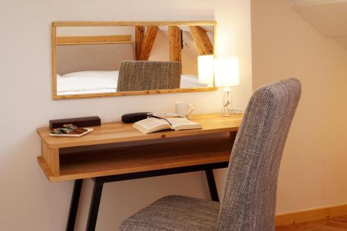 a desk with a mirror and a chair in a room at Kamienica Na Nowo Apartamenty in Mrągowo