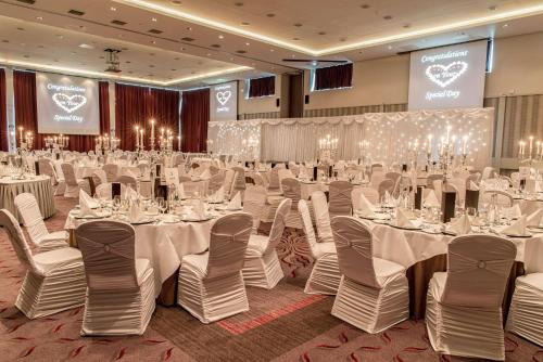 a banquet hall with white tables and chairs at Radisson BLU Hotel & Spa, Little Island Cork in Cork
