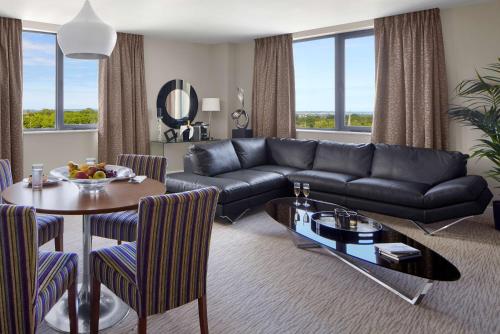 a living room with a black couch and a table at Radisson BLU Hotel Dublin Airport in Cloghran