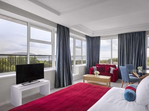 a hotel room with a bed and a tv and windows at Radisson BLU Hotel & Spa, Sligo in Sligo