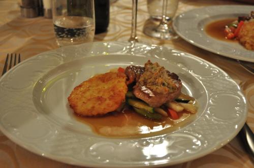 a plate of food with meat and vegetables on a table at Hotel Öhlerhof in Lagundo