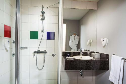 a bathroom with a sink and a shower at Park Inn by Radisson Frankfurt Airport in Frankfurt/Main
