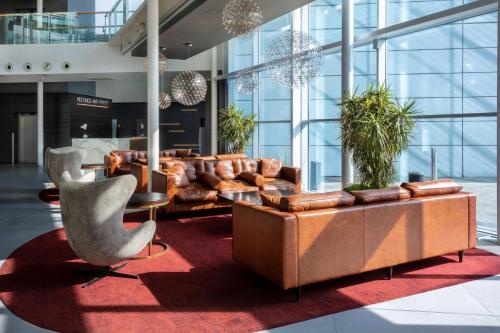 a lobby with couches and chairs in a building at Radisson Blu Hotel London Stansted Airport in Stansted Mountfitchet