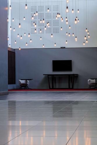 a room with a table and a television and lights at Radisson Blu Hotel London Stansted Airport in Stansted Mountfitchet