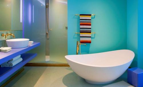 a bathroom with a large tub and a sink at Symphony Style Hotel Kuwait in Kuwait