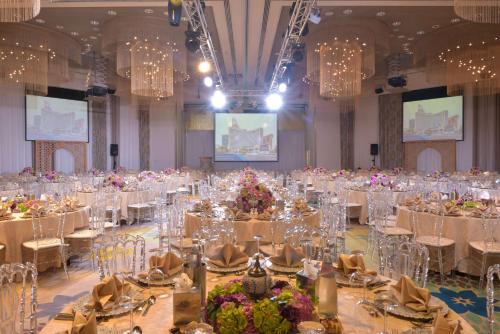 a large banquet hall with tables and chairs at Symphony Style Hotel Kuwait in Kuwait