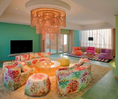 a living room with a couch and chairs and a chandelier at Symphony Style Hotel Kuwait in Kuwait