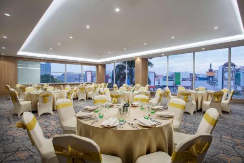 a banquet hall with tables and chairs and windows at Radisson Medan in Medan