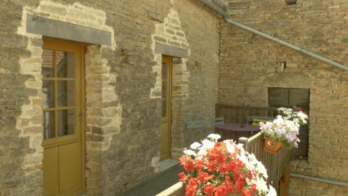 a brick building with a door and flowers on a balcony at gîte de la Cabotte in Bussy-le-Grand