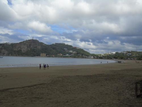 a group of people walking on the beach at Hostal Villas Mexico in San Juan del Sur