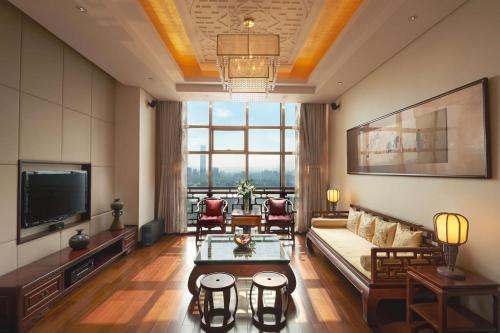 a living room with a couch and a tv at Radisson Blu Hotel Liuzhou in Liuzhou
