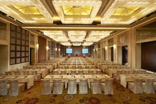 un gran salón de banquetes con mesas y sillas blancas en Radisson Blu Hotel Liuzhou, en Liuzhou